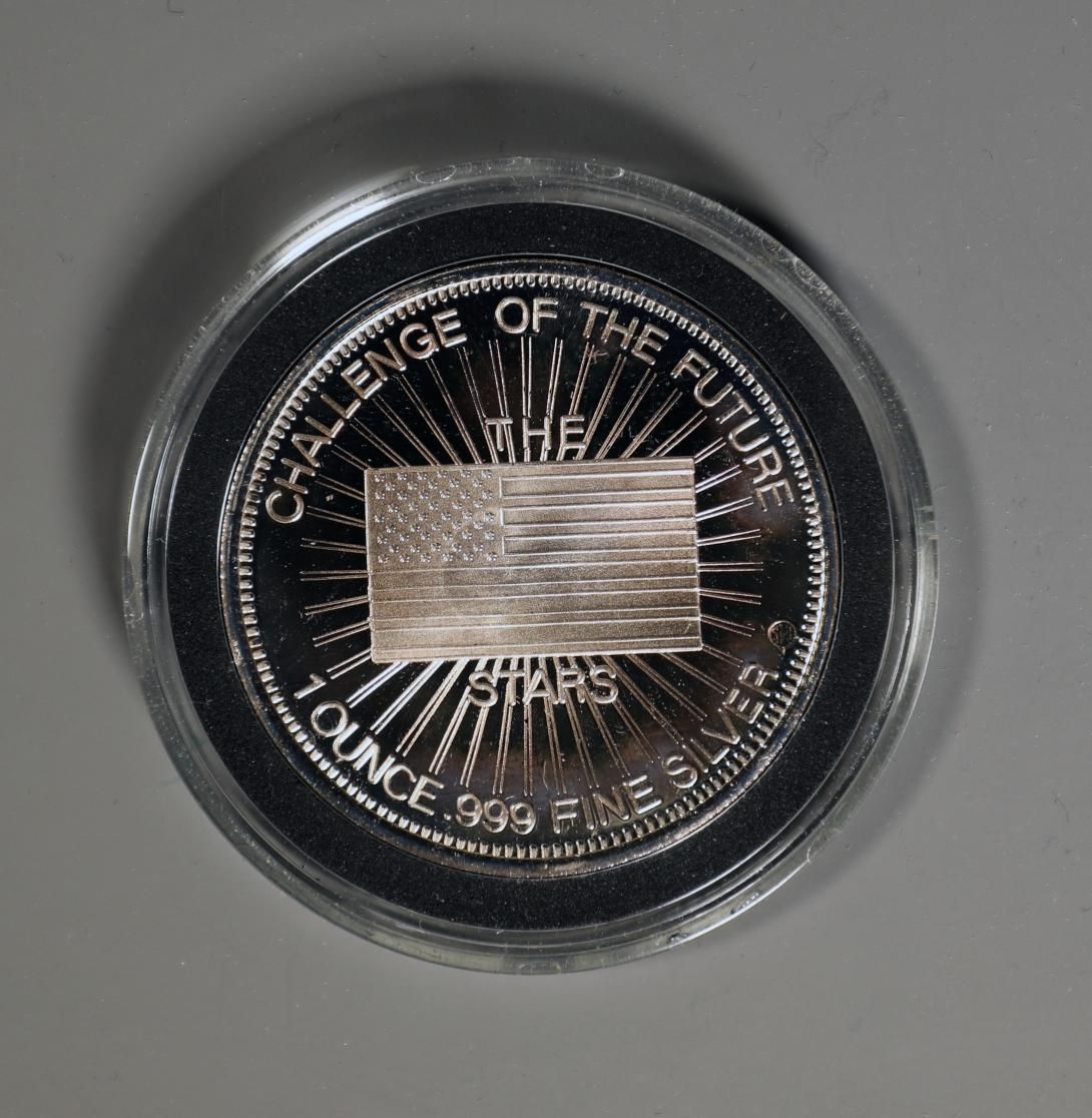 [Side 2 of 2] Challenger Commemorative Coin Artifact ID: 1987.02013.01a-b Object Name: Coin, Commemorative Maker: Dale L. Jones, Secretary-Treasurer, Silver Trust Investments Inc. Date Made: 1986  A silver commemorative coin encased in a plastic holder for the Space Shuttle Challenger made by Donor Dale L. Jones. 